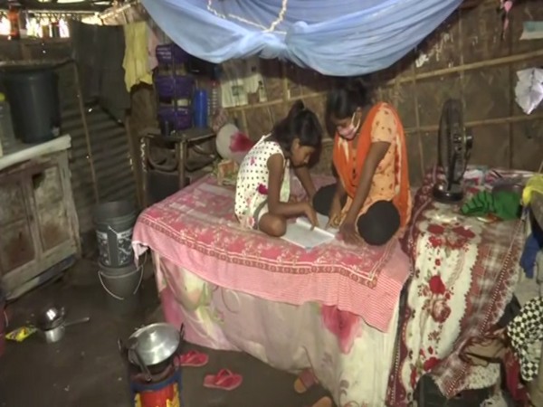 Children living in Guwahati's Pandu area studying from books (Photo/ANI)