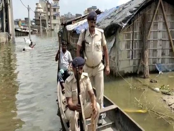 Police personnel  in a boat to Ahiyapur police station (Photo/ANI)