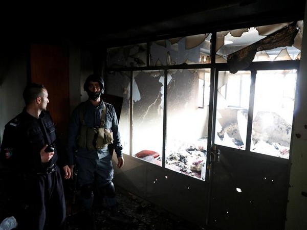 Afghan policemen inspect inside a Sikh religious complex after an attack in Kabul