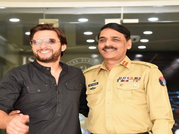 Former Pakistani cricketer Shahid Afridi (L) and Pakistan Army spokesman Asif Ghafoor