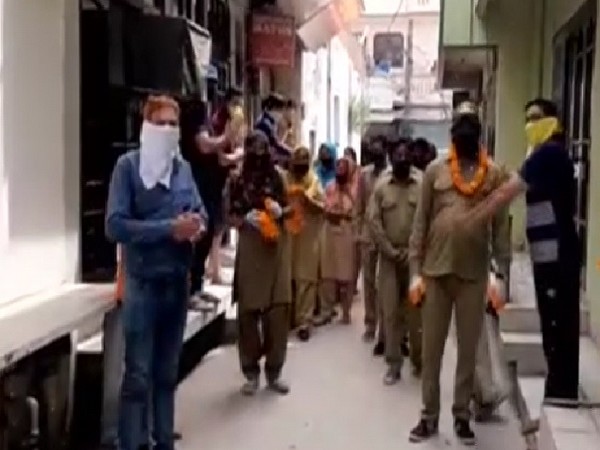 Locals in Ambala garlanding and showering flowers on sanitation workers on Thursday. Photo/ANI