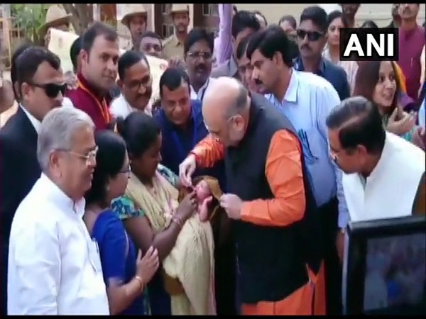 Home Minister Amit Shah administers polio drops to a child on Pulse Polio Day 2020 in Hubballi on Sunday.