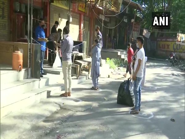 Customers waiting for their turn to purchase items from a shop in Amritsar on Friday. (Photo/ANI)