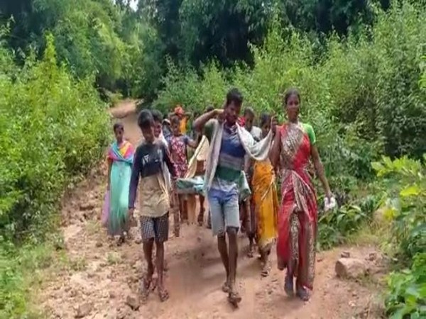 Villagers carry a pregnant woman on a make-shift cot for around 11 kilometres through a rough path. (Photo/ANI) 