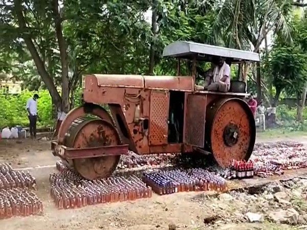 The Krishna district police on Friday destroyed liquor bottles worth approximately Rs 72 lakh, seized in different cases by a road roller. (Photo/ANI)