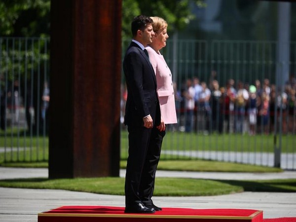 German Chancellor Angela Merkel and Ukrainian President Volodymyr Zelensky standing for national anthems outside the chancellery in Berlin on Tuesday. 