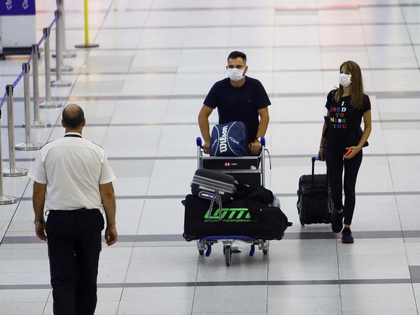 People in face masks walk at Ministro Pistarini International Airport in Buenos Aires