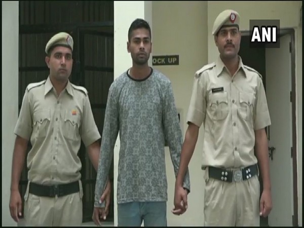 Ravindra Kumar, centre, in police custody.