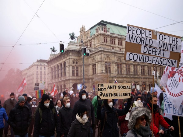 Demonstrators hold flags and placards as they march in front of the State Opera to protest against the coronavirus restrictions and the mandatory vaccination in Vienna. (Image credit: Reuters)