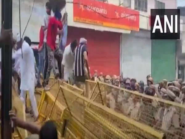 A group of farmers jumping over police barricades (Photo/ANI)