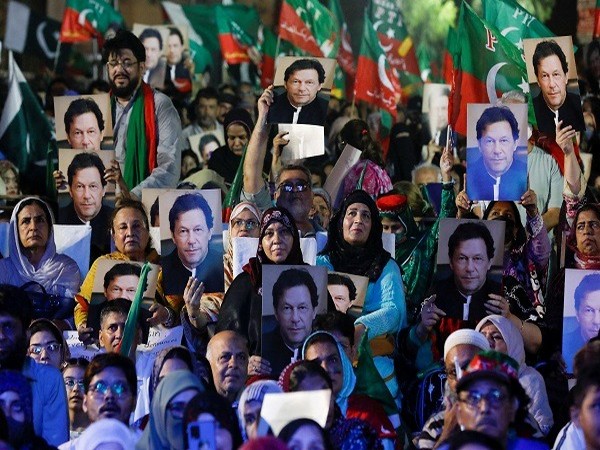 Supporters of the PTI carry posters, as they gather to listen the virtual address of the ousted Prime Minister Imran Khan, during a countrywide protest on inflation in Karachi.  (Photo Credit)