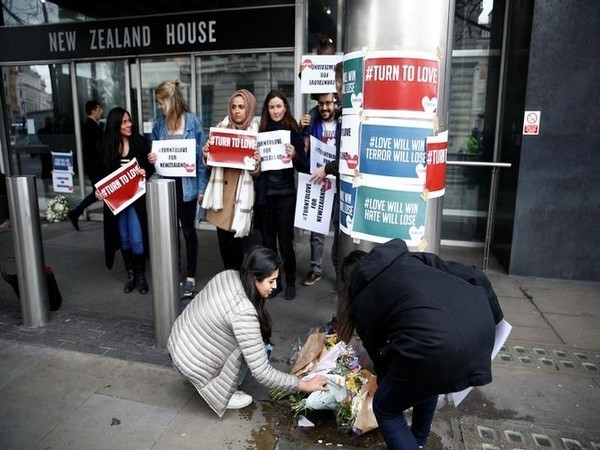 People place flowers following the deadly terror attacks at two mosques in Christchurch on Friday.