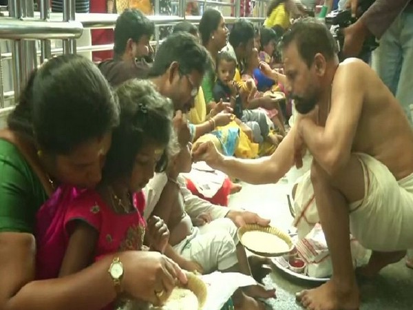 Children writing their name on a rice plate while the priest blessing the child during Sarwati Puja in Chennai in Tamil Nadu on Tuesday. Photo/ANI