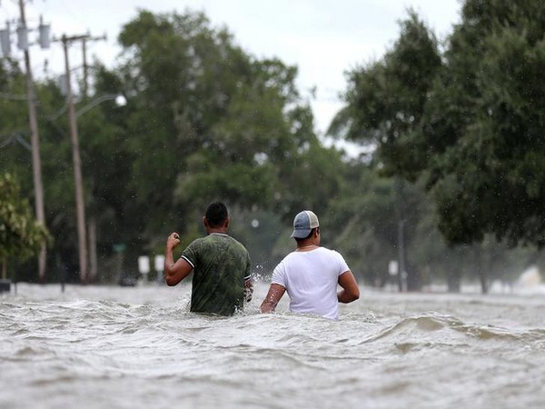 People wade through flood waters caused by Hurricane Barry in Mandeville, Louisiana on July 13 (Photo/Reuters)