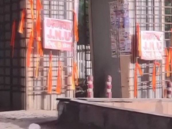 Bhagwa JNU' poster and saffron flag outside JNU gate. (ANI/photo)