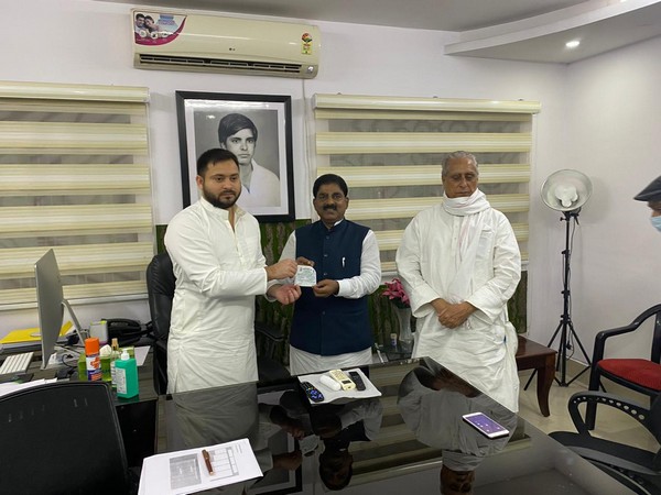 RJD leader Tejashwi Yadav inducting Bihar RLSP president Bhudeo Chaudhury in RJD. (Photo/ANI)