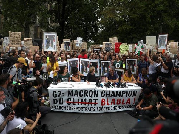 The protesters holding French President Emmanuel Macron's stolen portraits upside down during protests in Biarritz on Sunday (Photo/Reuters)