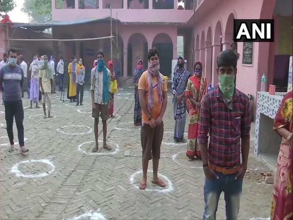 Voters maintain social distancing as they stand in queues to cast their votes in Raghopur Assembly constituency. (Photo/ANI)