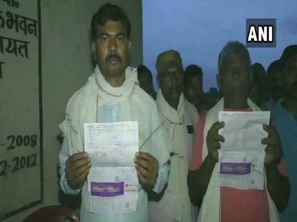Villagers holding electriciy bills that they reicived without having an electricity supply in Pateri Para of Sanawal village, Chattisgarh. Photo/ANI