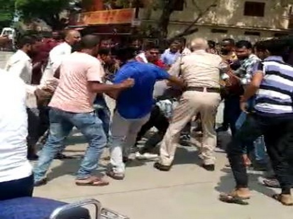 Locals thrashing the accused as the police man intervenes. Photo/ANI
