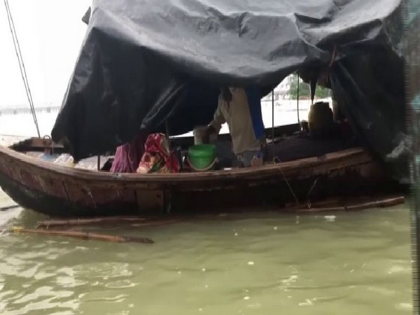 A family has been forced to live in a boat in Prayagraj due to flood. Photo/ANI