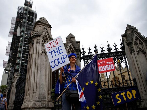 A protester holding a placard in London on Aug 31 (Photo/Reuters)