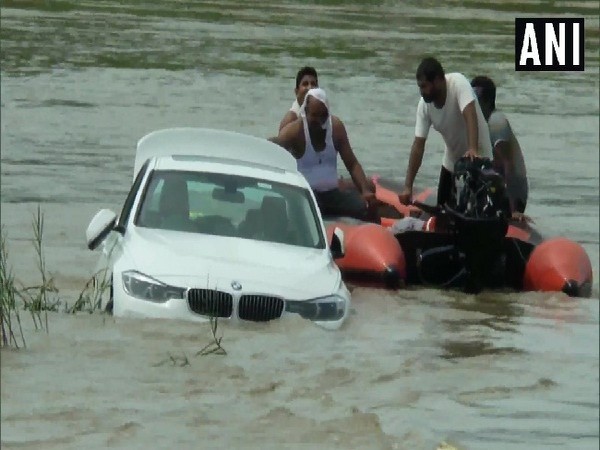 Rescue workers taking out BMW car from a canal in Yamunanagar.