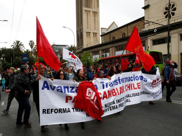 Demonstrators carry banner and flags as they march during a protest against the government in Valparaiso on Saturday