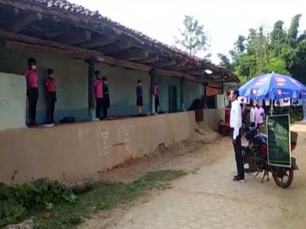 A government school teacher in Chhattisgarh's Korea district travels around on his bike, with a blackboard to educate children by holding 'mohalla' classes. (Photo/ANI) 