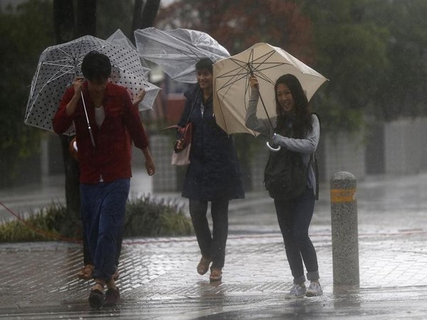 Passers-by with umbrellas struggle against strong winds and heavy rain caused by Typhoon Phanfone.