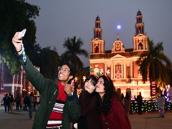 Devotees take a selfie in front of the Sacred Heart Cathedral Church in Delhi. (Photo/ANI)