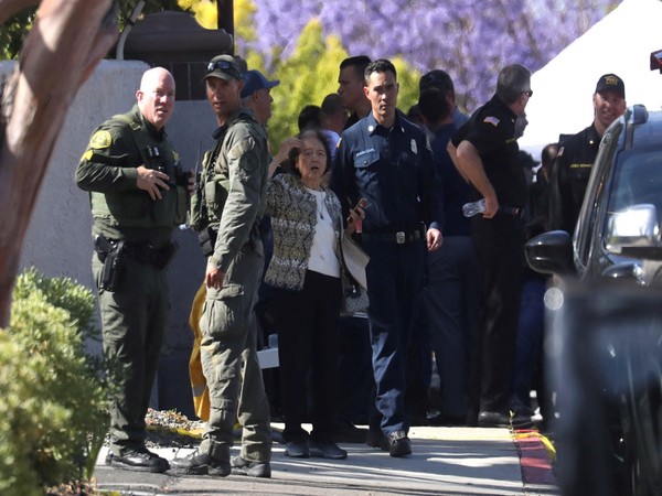 A woman reacts next to law enforcement officers after a deadly gunfire erupted at Geneva Presbyterian Church in Laguna Woods, California, US (Photo Credit: Reuters)