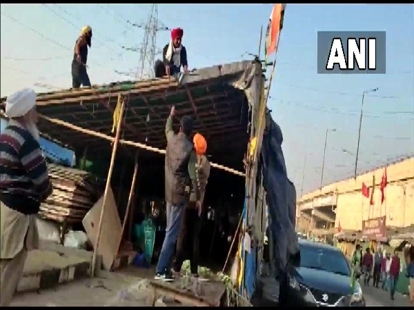 Farmers take down their tents at Ghazipur border (Photo/ANI)