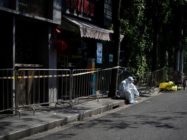    A worker in protective suit rests on a street during a lockdown, amid the coronavirus disease (COVID-19) pandemic, in Shanghai, China, April 17. (Photo Credit: Reuters)