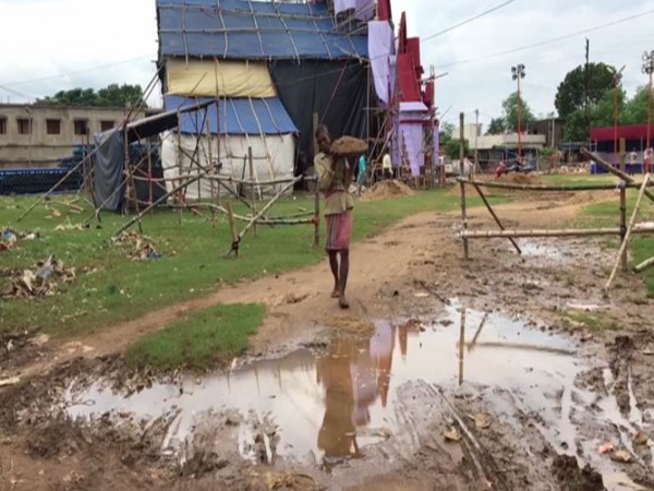 A worker filling soil in the water-logged area of a pandal in West Bengal's Midnapore on Wednesday. Photo/ANI