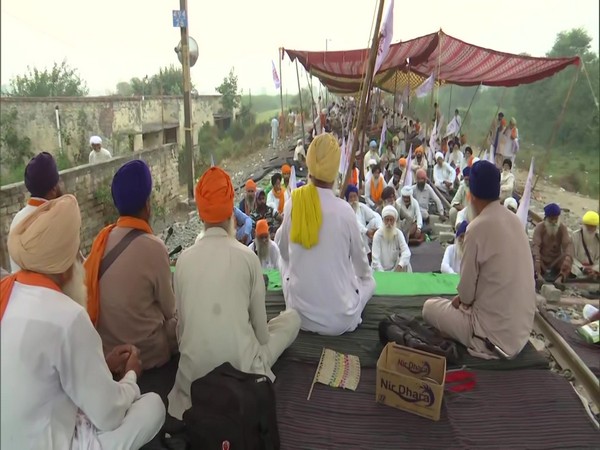 Protesters under the banner of Kisan Mazdoor Sangharsh Committee sitting at railway tracks as part of protest against farm Bills. (Photo/ANI)