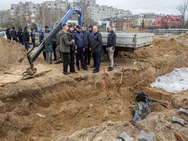 International Criminal Court (ICC) Prosecutor Karim Khan stands next to a mass grave in the town of Bucha (Photo Credit: Reuters)