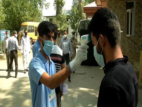 A NEET candidate getting his temperature checked before entering the examination centre. (Photo/ANI)