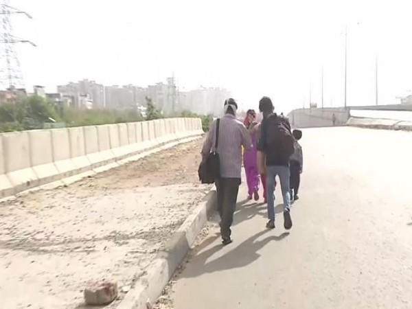 The family of a daily wage earner leaving for their native village at Delhi-Ghazipur border on Thursday. Photo/ANI