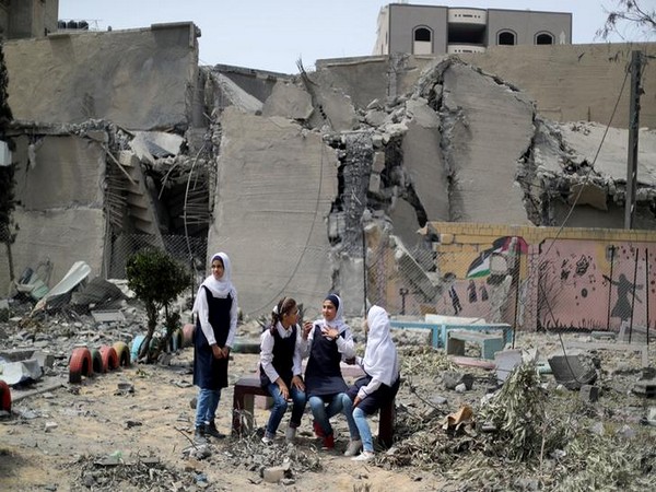 Palestinian students are seen inside their damaged school nearby a building that was destroyed by Israeli air strikes, in Gaza City on Tuesday (May 7)