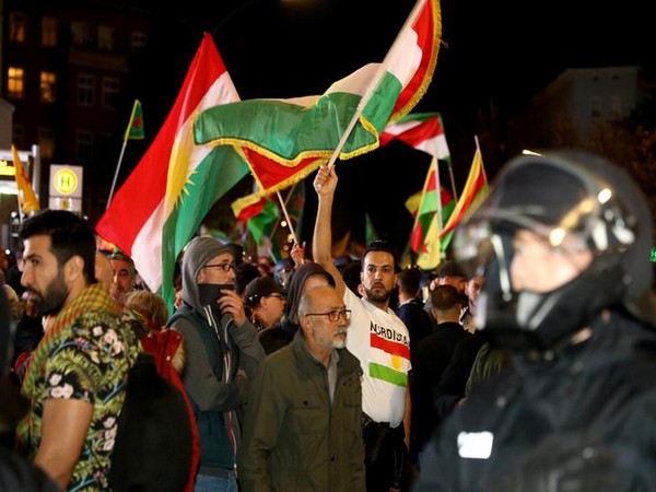Kurdish protesters waving a flag during a demonstration against Turkey's military action in northeastern Syria, in Berlin, Germany on Saturday. (Reuters)