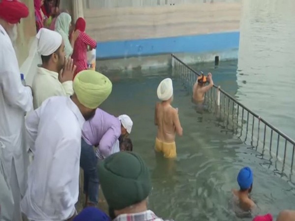 Sikhs taking a holy dip in Golden temple in Amritsar [Photo/ANI]