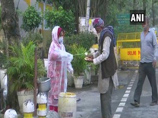 Locals of the city distribute food among the needy, outside Gurdwara Bangla Sahib in Delhi on Saturday.
