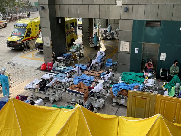 Patients wearing face masks lie in bed at a makeshift treatment area outside a hospital, following the COVID-19 outbreak in Hong Kong. (Photo Credit - Reuters)