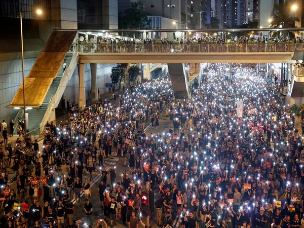 Protesters use flashlights of mobile phone during the march on July 1