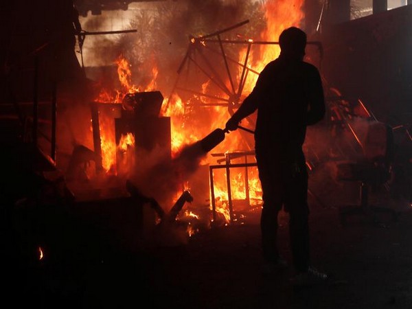 A man extinguishes fire at the Hong Kong Polytechnic University during the ongoing anti-government protests on Monday