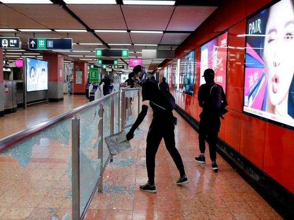 Anti-government protesters wearing mask smash Mong Kok Mass Transit Railway (MTR) station during a demonstration on Friday.