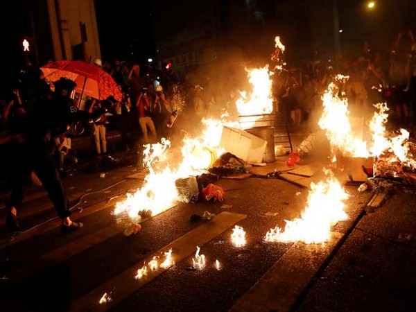 An anti-government protester sets fire during a rally outside Mong Kok police station, in Hong Kong