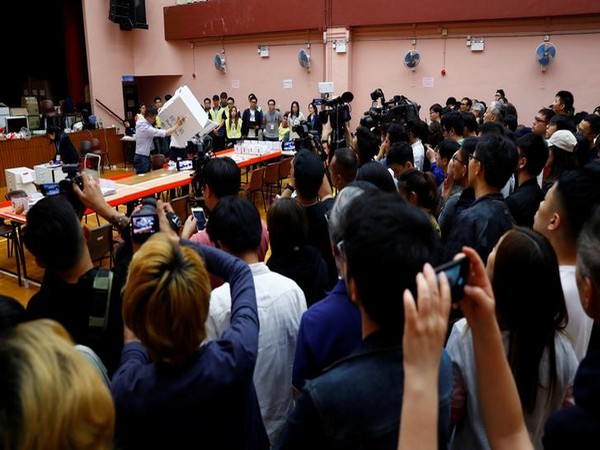 Members of the media and the public watch the counting process at the polling station in the South Horizons West district in Hong Kong