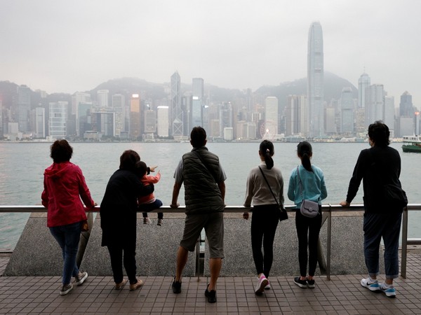 A Hong Kong-based family -- which emigrated to Scotland last year -- look out over the city's skyline on an outing to Tsim Sha Tsui in Hong Kong. (Image credit: Reuters)